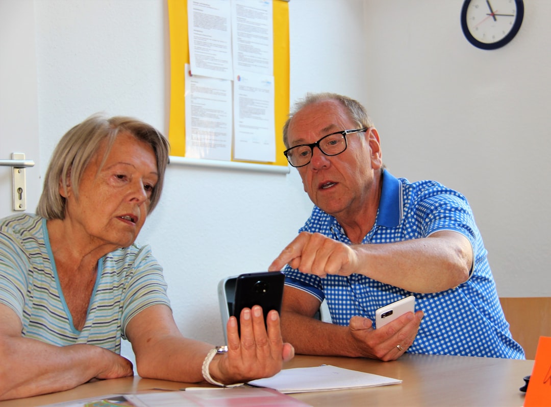 Pflegefachkraft kommuniziert über ein modernes Telefon auf einer Klinikstation